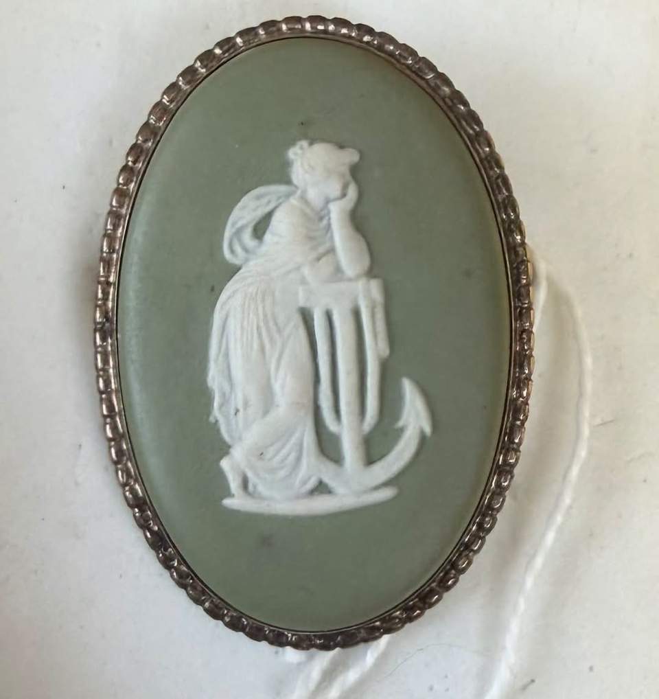 The item appears to be a vintage green Wedgwood Jasperware cameo brooch featuring a classical "Hope and Anchor" motif in a silver-toned or hallmarked setting.