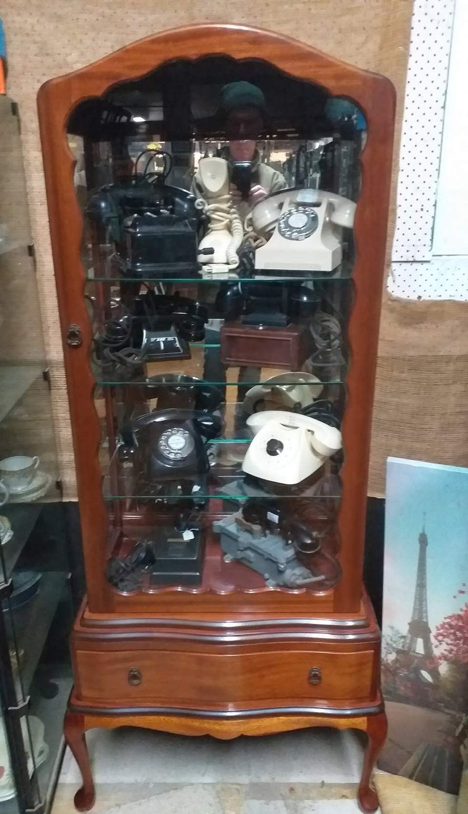 Mahogany display cabinet full of phones